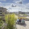 Groepje mensen aan een picknicktafel op een groen dakterras.